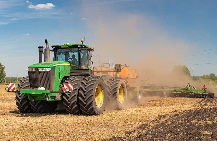 Tractor grande y verde trabajando la tierra