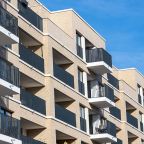 Fachada de pisos con el cielo azul de fondo