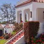 Exterior casa vacacional con escaleras, mucha vegetación y flores