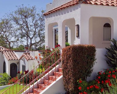Exterior casa vacacional con escaleras, mucha vegetación y flores